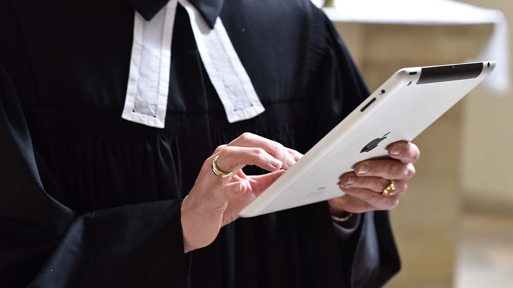 So kann ein Gottesdienst heutzutage auch aussehen: Eine Pfarrerin liest die Bibel auf ihrem iPad. Der Beruf müsse insgesamt zeitgemäßer gestaltet werden, meinen Experten