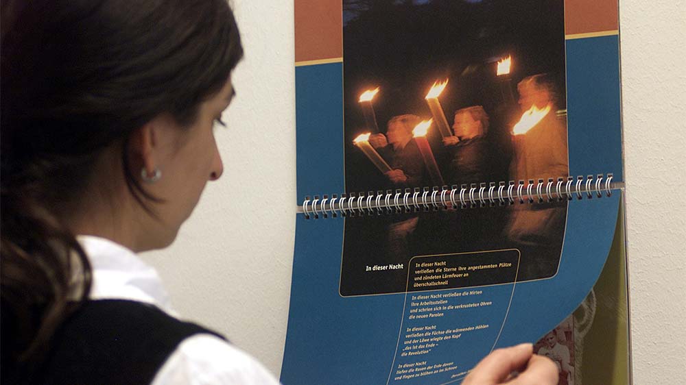 Eine Frau betrachtet den Kalender "Der Andere Advent" des Hamburger Vereins "Andere Zeiten"