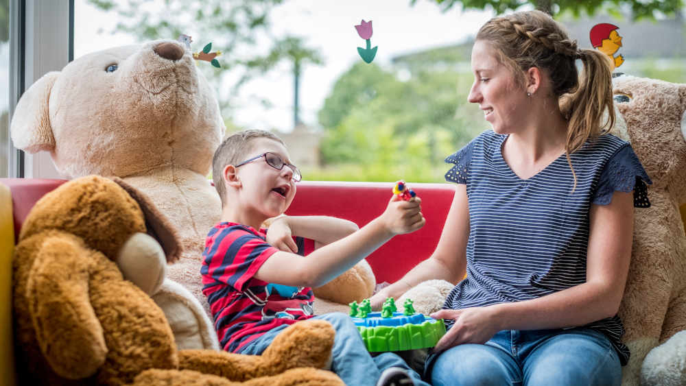 Die Krankenschwester Carolin Gießler und der sechsjährige Sandro spielen und lesen gemeinsam im Kinderhospiz Balthasar in Olpe