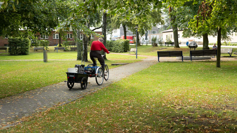 Bewohnerin mit Fahrrad und Anhänger auf dem Gelände der Hoffnungstaler Stiftung Lobetal