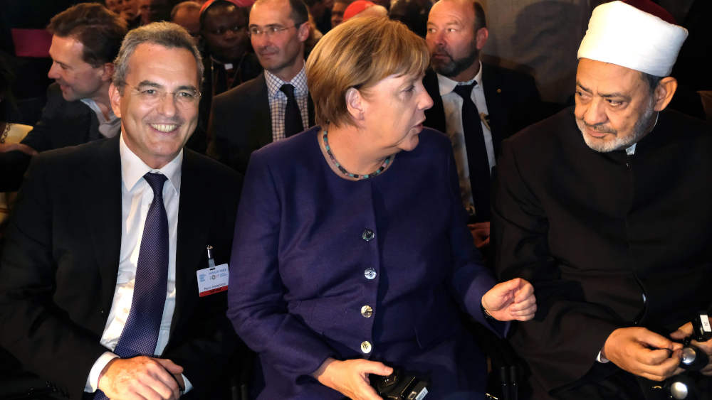 Präsident der Gemeinschaft Sant'Egidio ist seit 2003 der Italiener Marco Impagliazzo (li.), hier 2017 mit Ex-Bundeskanzlerin Angela Merkel beim internationalen Friedenstreffen der katholischen Laienbewegung Sant Egidio in Münster