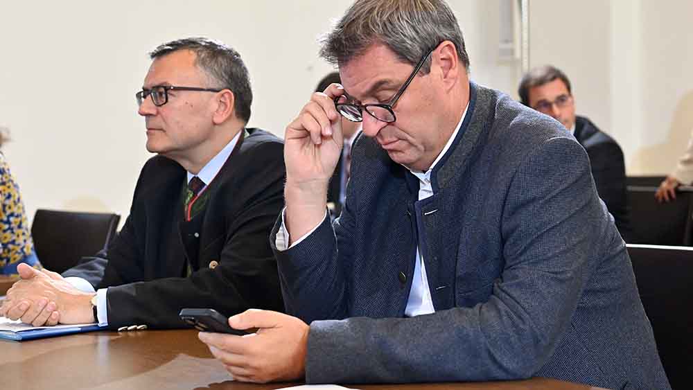 Ministerpräsident Markus Söder schaut während der Sitzung interessiert auf sein Smartphone