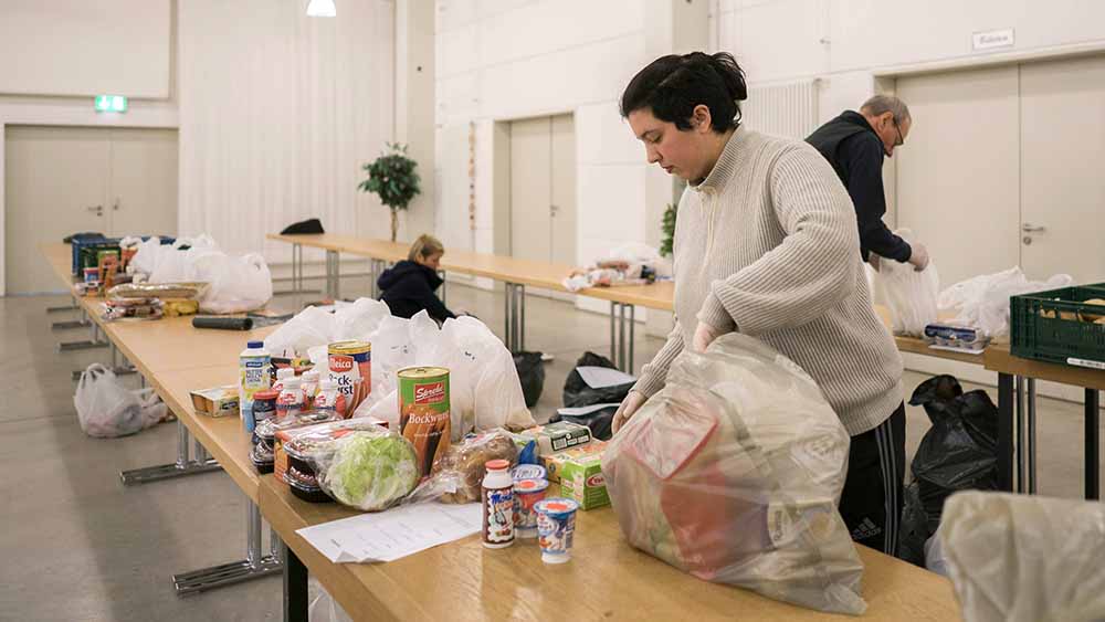 Frau packt Pakete mit Lebensmitteln