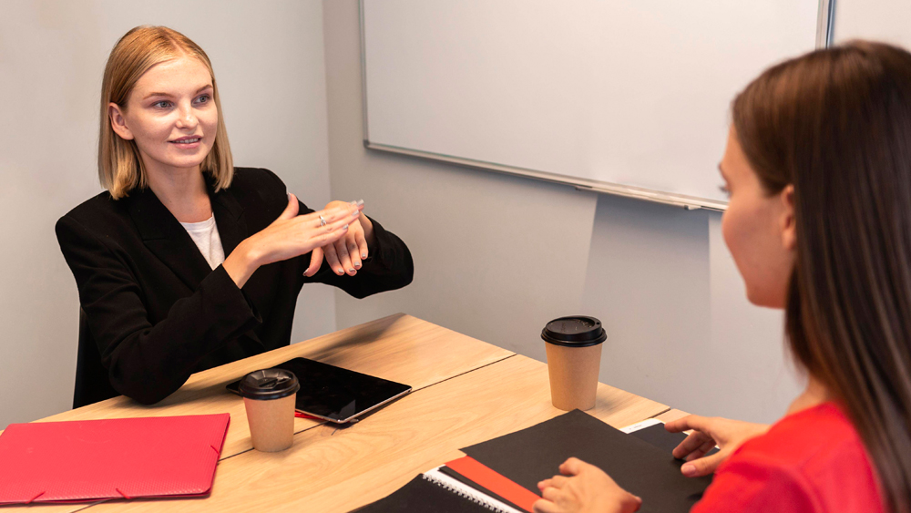 Zwei Geschäftsfrauen unterhalten sich in Gebärdensprache