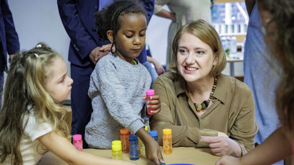 Paus an einem Tisch mit Kindern