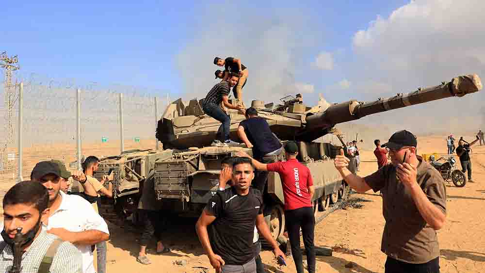 Palästinenser nehmen einen israelischen Panzer an der Grenze zum Gaza-Streifen in ihre Kontrolle
