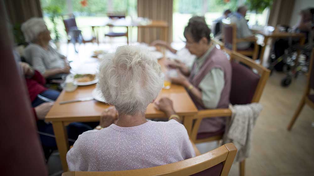 In großer Runde sitzen Bewohnende eines Altenheims zusammen (Symbolbild)