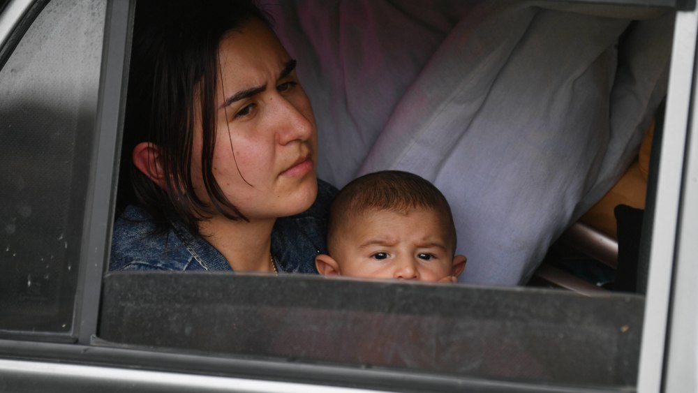 Eine geflüchtete Frau mit ihrem Kind wartet auf Hilfe