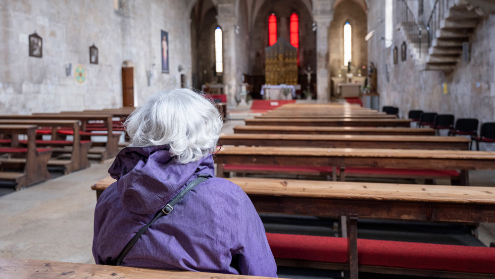 Kirche mit einer älteren Besucherin
