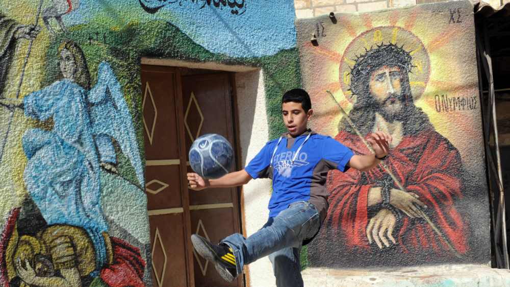 Ein christlicher, palästinensischer Junge vor eine Jesus-Wandgemäde in der Westbank