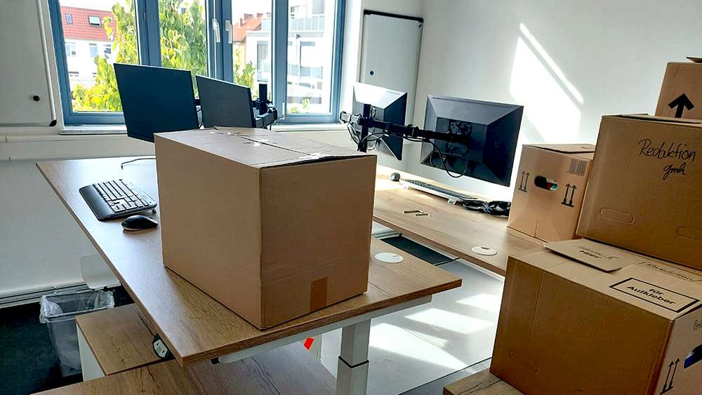 In den neuen Redaktionsräumen werden die Umzugskartons ausgepackt und alles eingerichtet