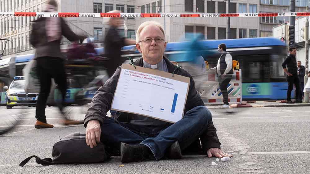 Jesuitenpater Jörg Alt klebt sich immer wieder an Straßen fest, hier in München. dafür wird er jetzt rechtskräftig verurteilt