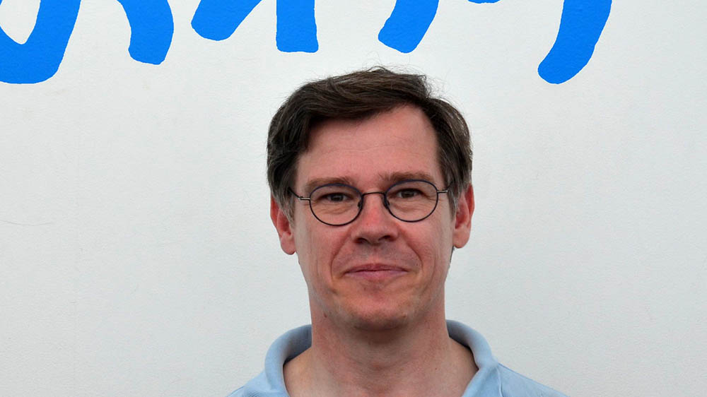 Mann mit Brille schaut in die Kamera