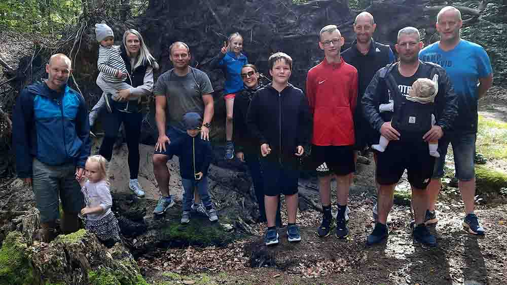 Gruppe von zehn Menschen steht im Wald