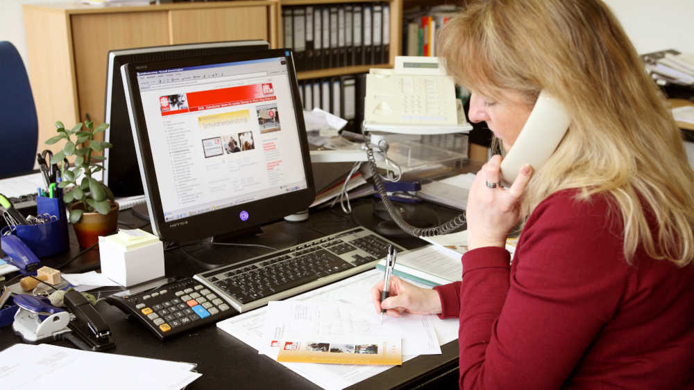 Eine Beraterin am Telefon im Gespräch mit einem Schuldner.