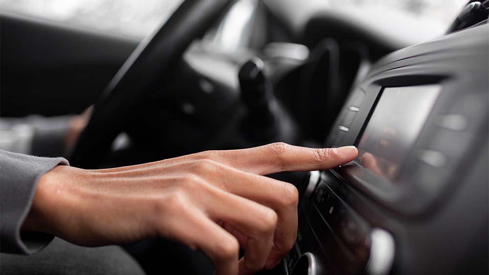 Finger berührt Autoradio