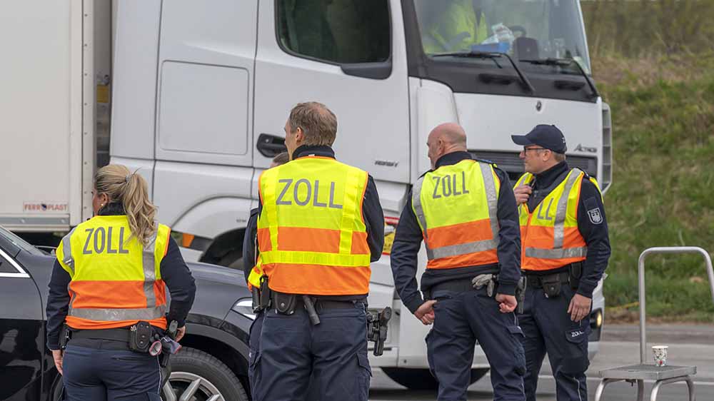 Vier Zoll-Beamte bei einer Kontrolle in gelben Westen