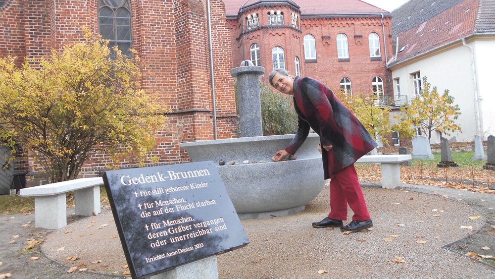 Gedenkbrunnen an der Liebfrauenkirche in Jüterbog mit Pfarrerin i.R. Mechthild Falk
