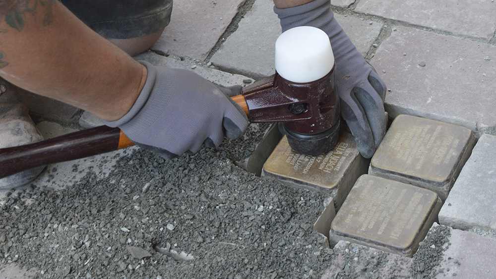 Die Stolpersteine werden fest in den Boden geklopft