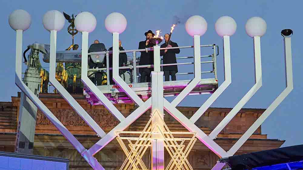 In zehn Metern Höhe entzündet Kanzler Olaf Scholz (r.) das Chanukka-Licht, Rabbiner Yehuda Teichtal unterstützt ihn
