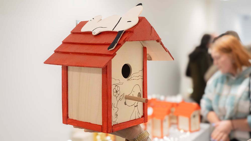 Ein von Hand gezimmertes Vogelhäuschen mit Snoopy Dekoration aus der JVA-Produktion wird in Bremen auf einem Adventsbasar verkauft