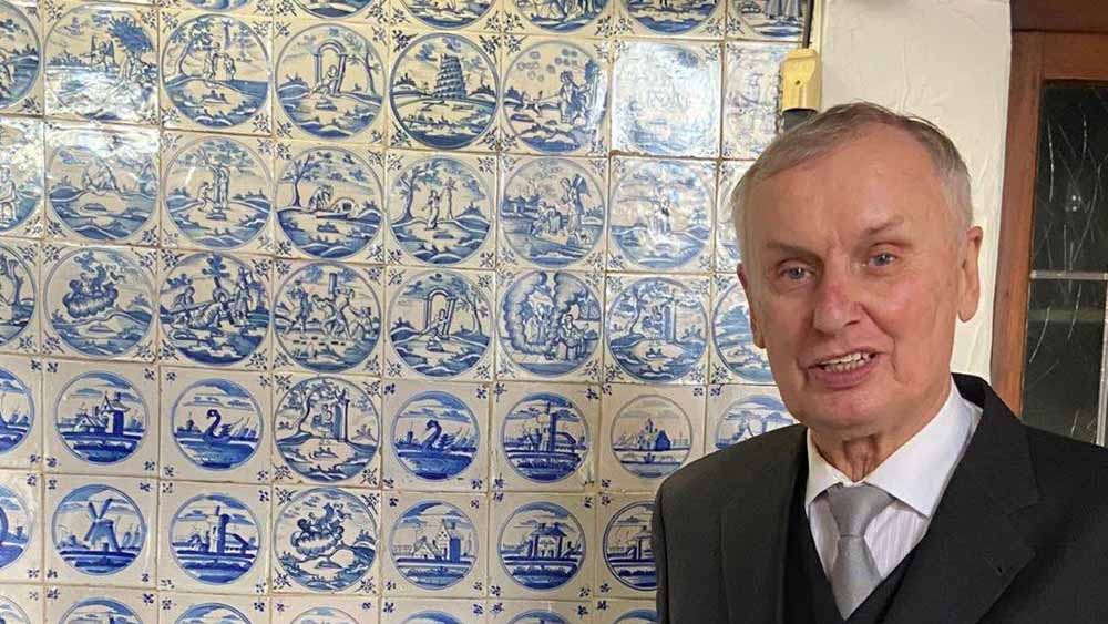 Pastor Perrey steht vor einer Wand mit friesischen Fliesen