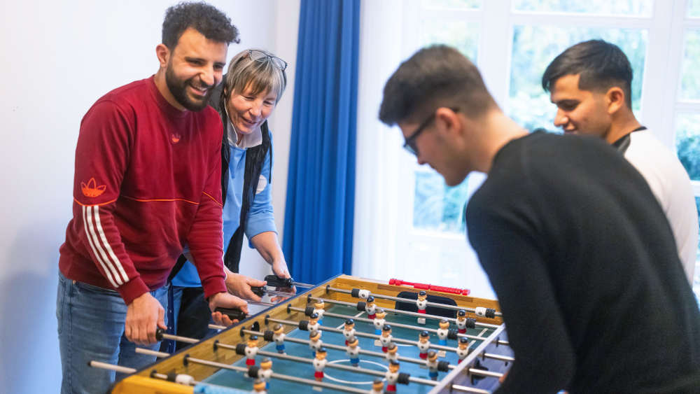 hatfan-Alfayad (l.) mit Teamleiterin Mechthild Broxtermann beim Tischkicker spielen in der vorläufigen Inobhutnahme der Caritas für unbegleitete minderjährige Ausländer