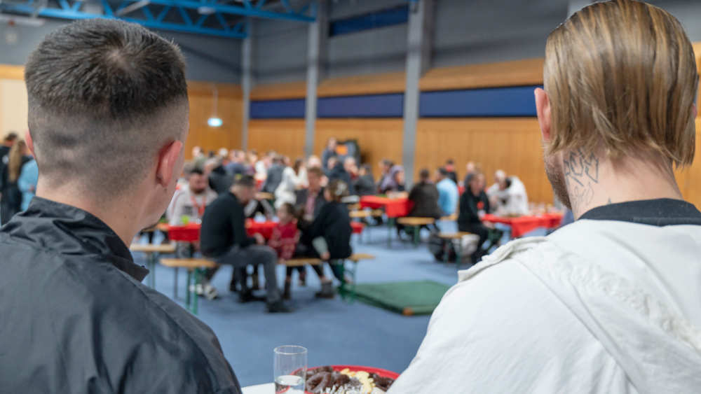 Von einem Stehtisch aus beobachten zwei Häftlinge der Justizvollzugsanstalt Uelzen das Treiben in der Turnhalle des Gefängnisses