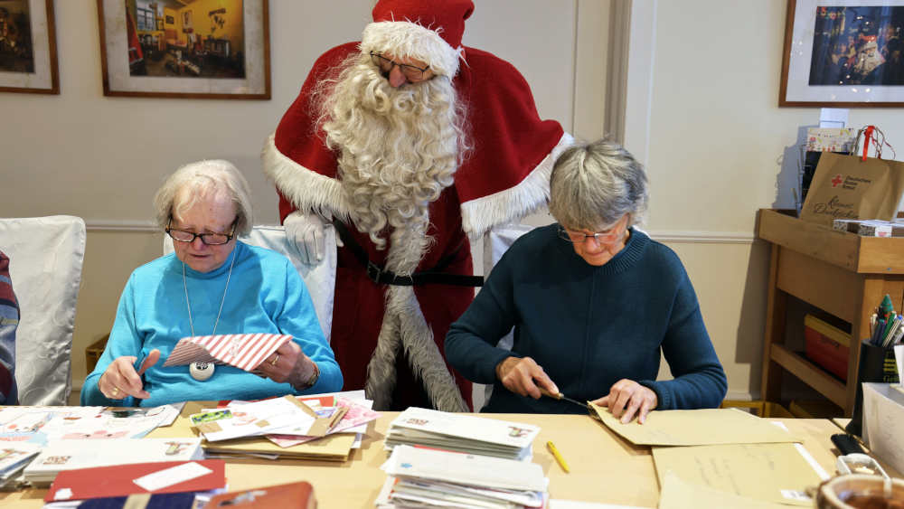 Kurzer Blick über die Schulter von zwei helfenden „Engeln“ in der himmlischen Schreibstube: Der Weihnachtsmann freut sich über die Unterstützung von Meta Stielper (r.) und Marga Plessman