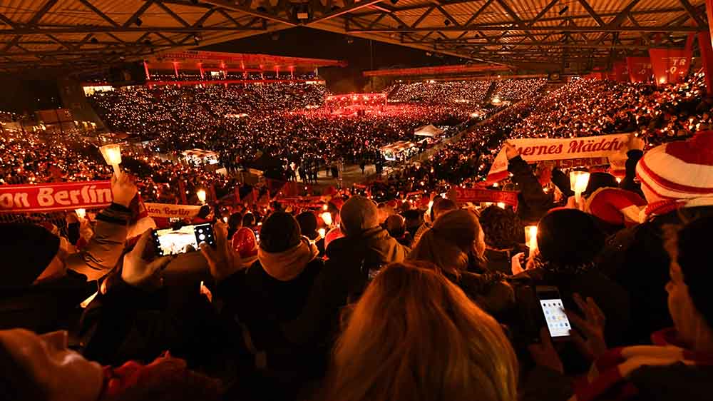 Nicht nur im Gottesdienst werden Weihnachtslieder gesungen, das Weihnachtssingen im Stadion von Union Berlin hat schon Tradition