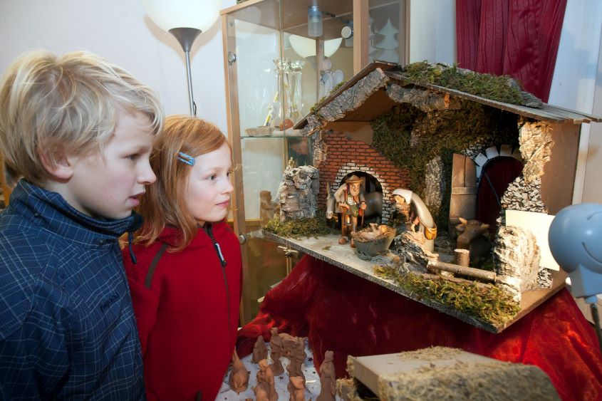 Zwei Kinder an einer Weihnachtskrippe 