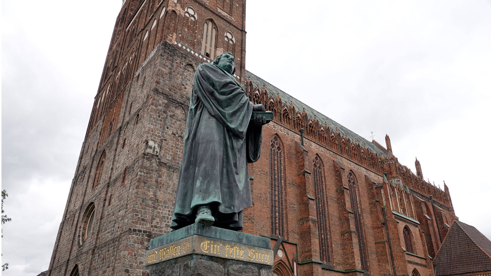 St. Marienkirche in Prenlau mit dem Lutherdenkmal davor