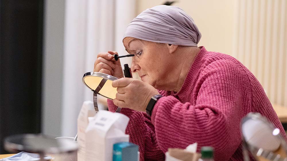 Patientin Brigitte Weihmüller schminkt sich beim Kosmetikseminar für krebskranke Frauen