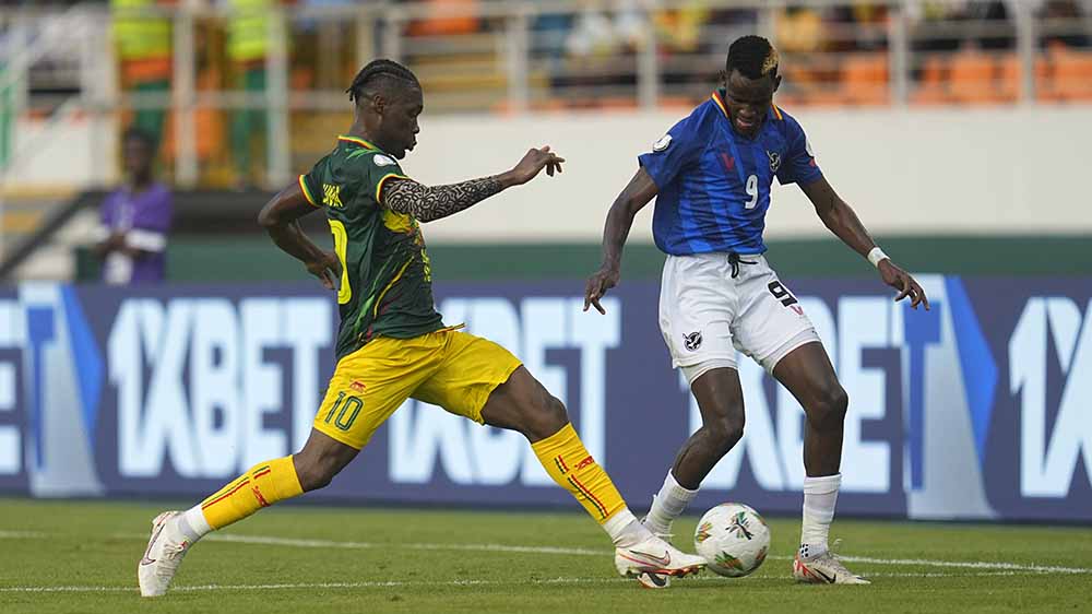 Yves Bissouma (Mali, li.) spitzelt Muzeu Betuel Muzeu (Namibia) den Ball vom Fuß