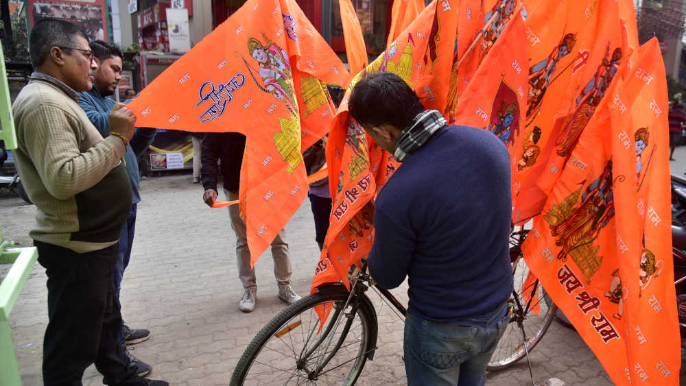 Vor der Feier zur Einweihung des Ayodhya-Ram-Tempels kaufen Menschen am Straßenrand Flaggen von Lord Ram