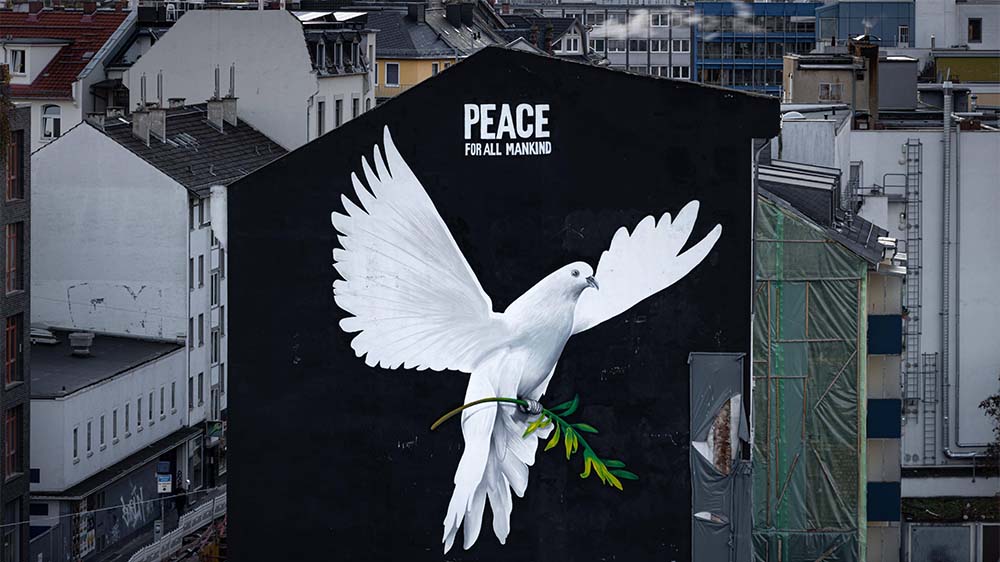 "Frieden für die ganze Menschheit" steht über dem Bild einer riesigen Friedenstaube an einer Hauswand in Frankfurt am Main (Symbolbild)