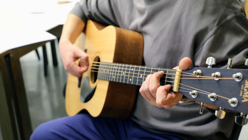 Ein Häftling übt an der Gitarre in der Justizvollzugsanstalt (JVA) Nürnberg. Musikangebote im Strafvollzug können den Gefangenen den Alltag erleichtern