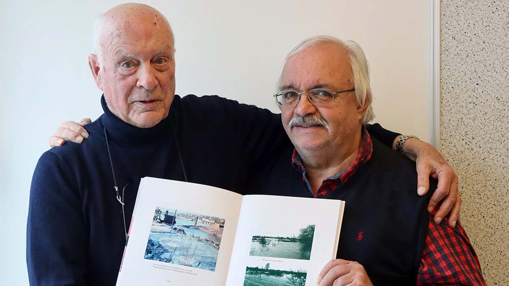 Zeitzeuge Johannes Tönnies (links) mit Bildern aus seinem neuesten Buch, das er über die Sturmflut geschrieben hat