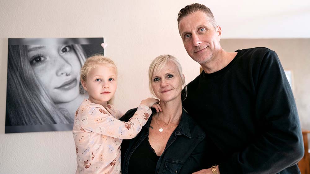 Ivonne und Torsten mit ihrer kleinen Tochter. Im Hintergrund ein Bild von Line, ihrer Tochter, die auf tragische Weise ums Leben gekommen ist