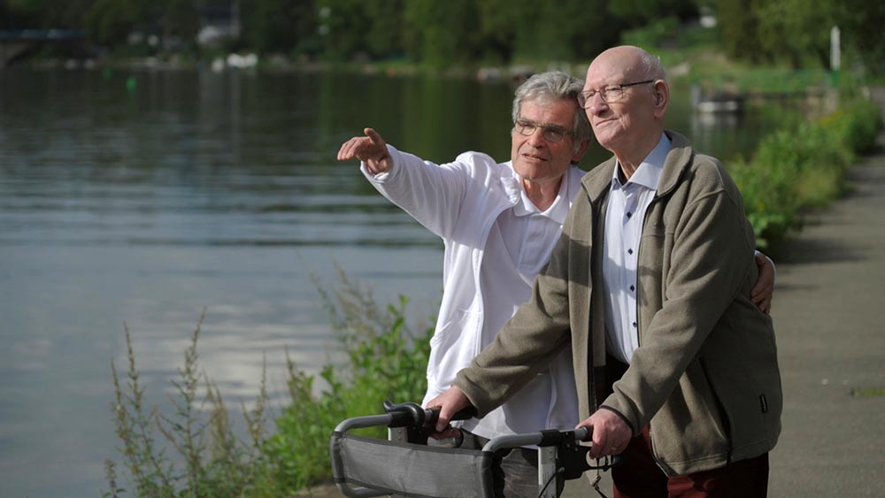 Oskar Dierbach (l.), Erfinder des rehabilitativen Pflegekonzepts, und Pflegeheim-Bewohner Klaus Grün (r.) beim Spaziergang in Mühlheim an der Ruhr