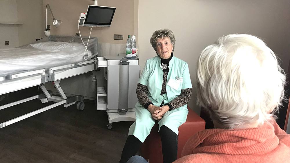 Inge Voth im Gespräch mit einer Krankenhauspatientin. Sie nimmt sich Zeit, um zuzuhören und zu trösten