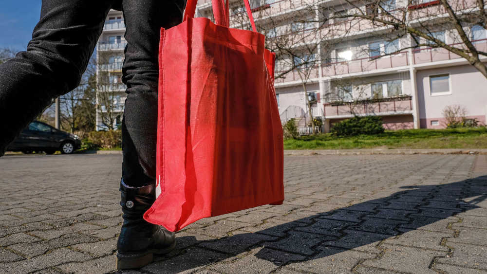 Eine freiwillige Helferin besorgt Einkäufe für den Nachbarn