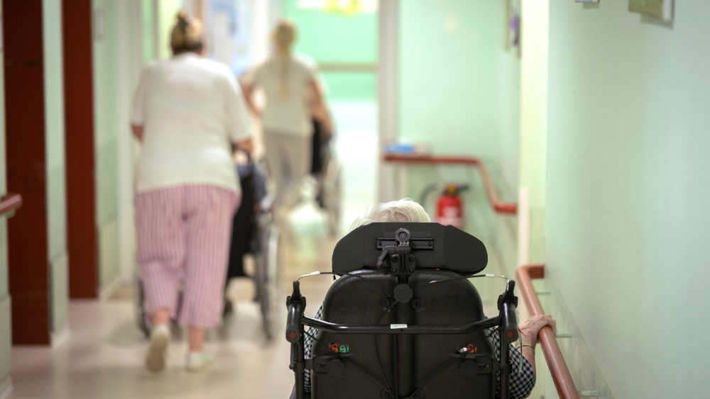 Eine Bewohnerin im Rollstuhl auf dem Flur im Altenpflegeheim