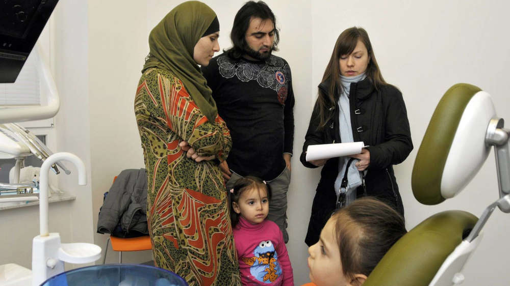 Eine Dolmetscherin übersetzt in einer Zahnarztpraxis die Ausführungen vom Arzt ins Russische