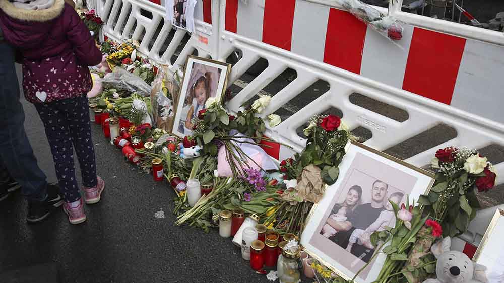 Vor dem abgesperrten Haus haben Menschen Blumen und Kerzen niedergelegt
