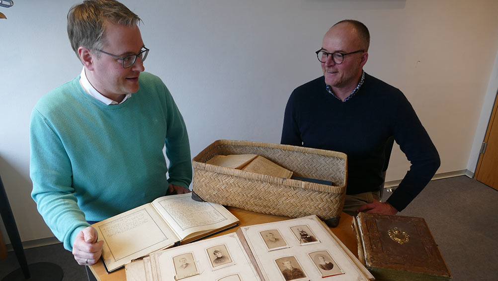 Kai Nilson (r.) übergibt einen Bastkoffer aus dem Nachlass von Martha Köppen-Bode an Heiko Suhr von der Ostfriesischen Landschaftsbibliothek.