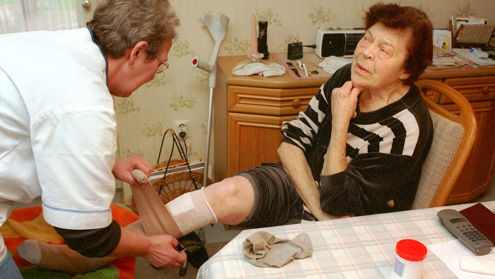 Eine Krankenschwester von der ambulanten Krankenpflege der ökumenischen Diakoniestation bei der Pflege einer Patientin