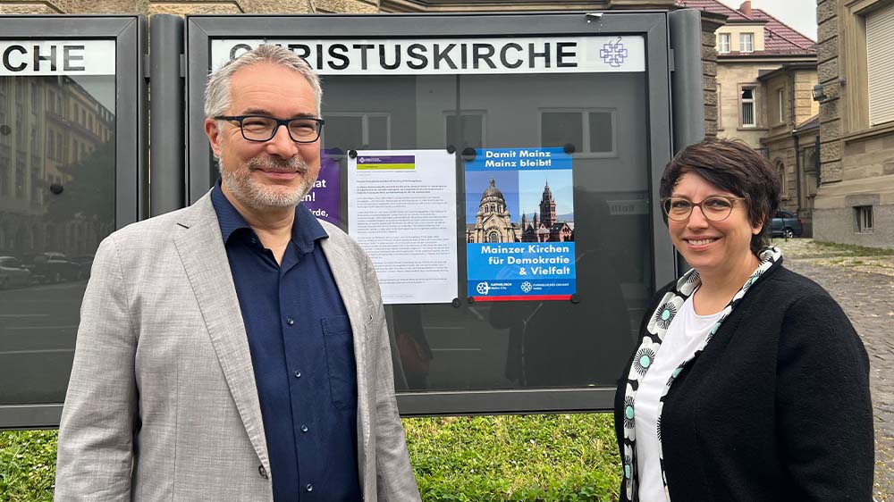 Pfarrerin Eva Lemaire und Dekan Andreas Klodt vor dem Schaukasten der Christuskirche Mainz