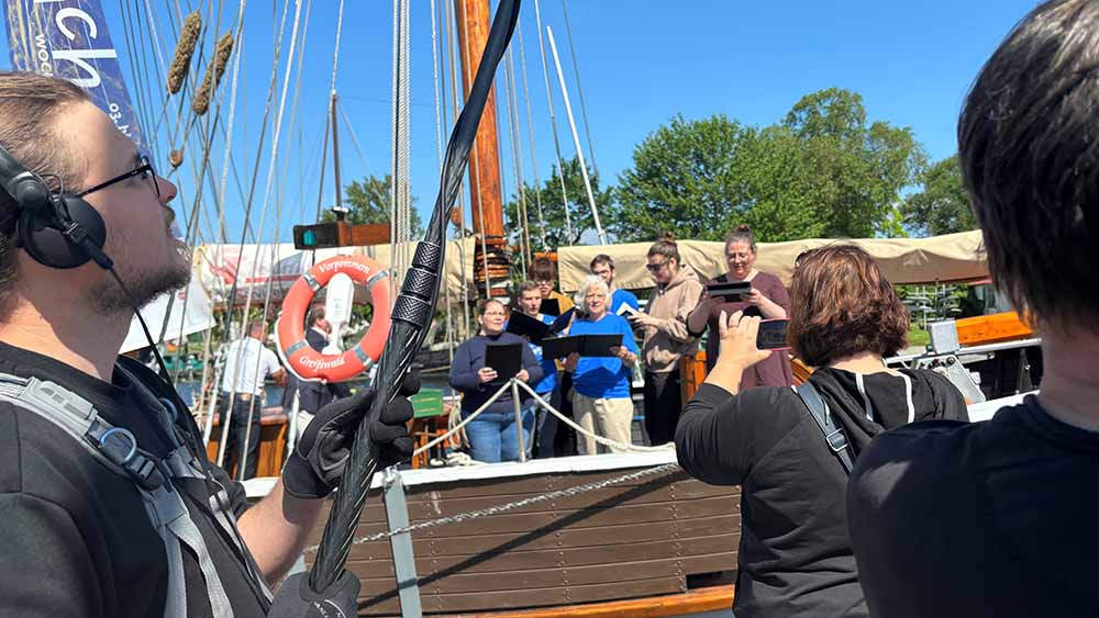 Einstimmung auf die Greifswalder Bachwoche, die am 3. Juni beginnt: Ein Chor singt, Presseleute fotografieren und nehmen auf.