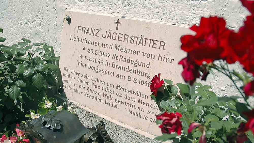Das Grab von Franz Jägerstätter steht vor der barocken Kirche von St. Radegund in Oberösterreich 